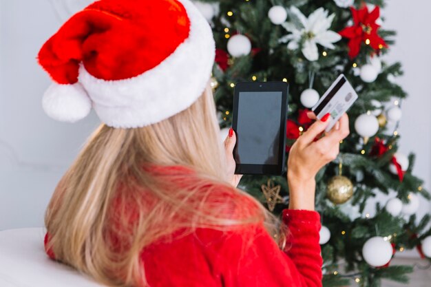 Vrouw in Kerstmanhoed met tablet