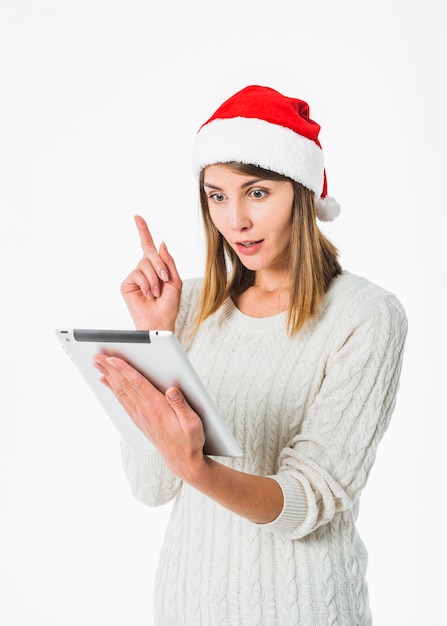 Vrouw in kerstmanhoed met tablet