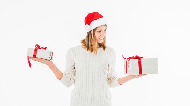 Vrouw in kerstmuts met geschenkdozen