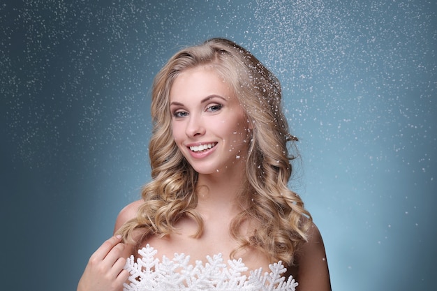 Vrouw in krullend blond kapsel en sneeuwvlok jurk