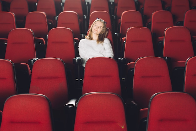 Vrouw in leeg bioscoopauditorium