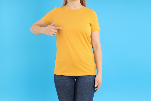 Vrouw in leeg oranje t-shirt op blauwe achtergrond