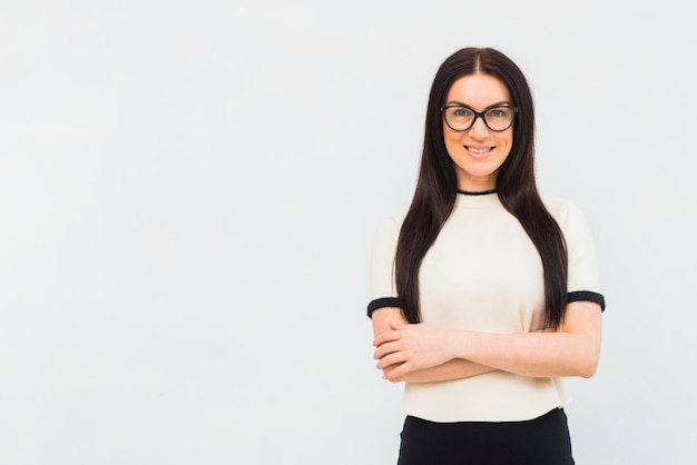 Gratis foto vrouw in lichte kleren die zich met gekruiste wapens bevinden