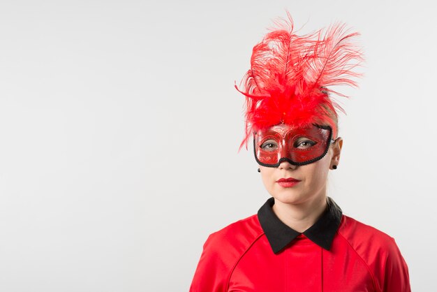 Vrouw in masker met rode veren