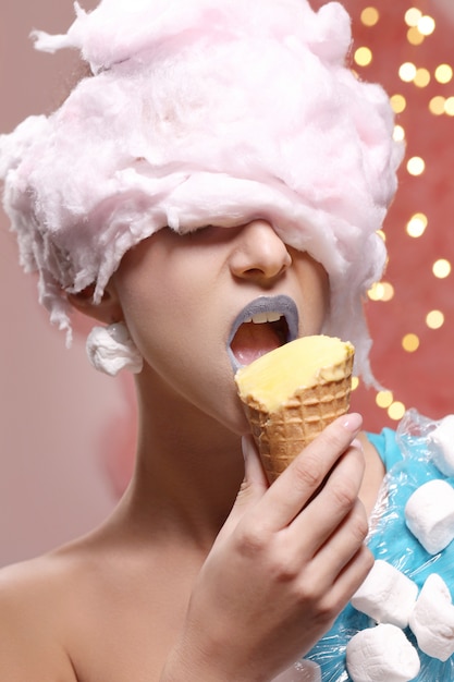 Vrouw in ongebruikelijke jurk gemaakt van marshmallow en pruik van suikerspin