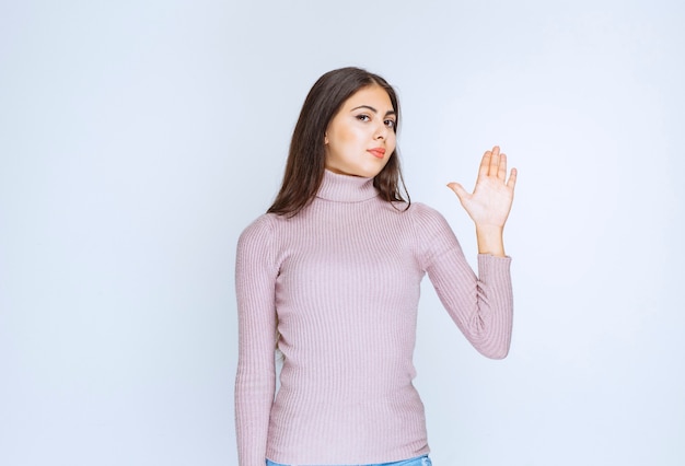 vrouw in paars shirt die iets afwijst met handgebaren.