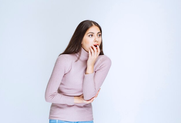 vrouw in paars shirt ziet er verrast en attent uit.