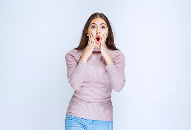 vrouw in paars shirt ziet er verrast en attent uit.