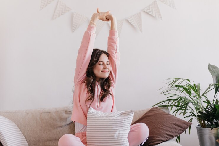 Gratis Foto vrouw in pyjama die zich uitstrekt op de bank