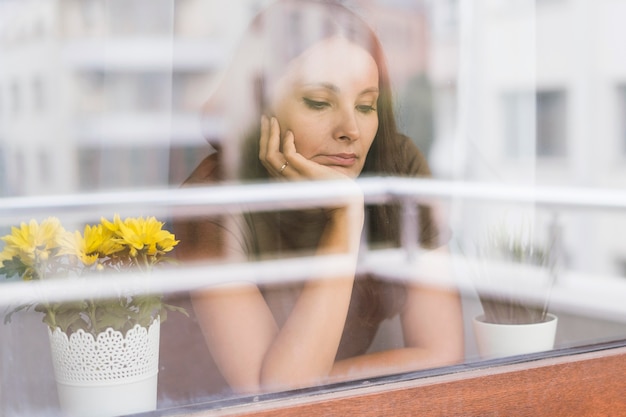 Vrouw in quarantaine kijkt door het raam