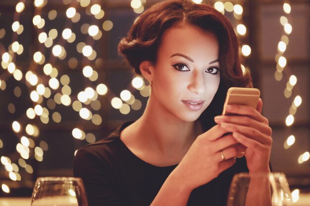 Vrouw in restaurant met behulp van de smartphone