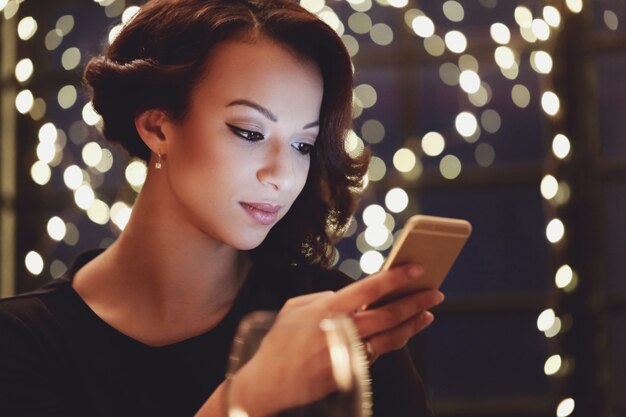 Vrouw in restaurant met behulp van de smartphone