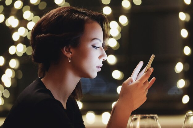 Vrouw in restaurant met behulp van de smartphone