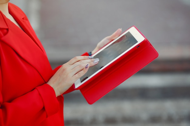 Vrouw in rode jas met behulp van een tablet