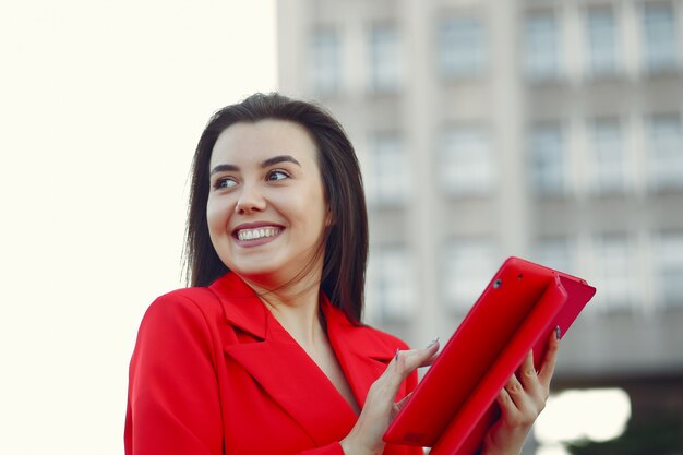 Vrouw in rode jas met behulp van een tablet