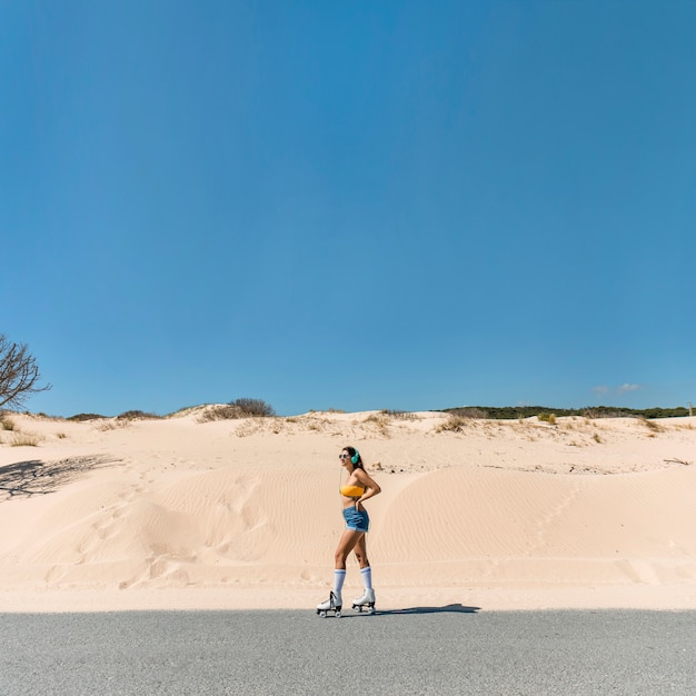 Gratis foto vrouw in rollen op zanderige weg