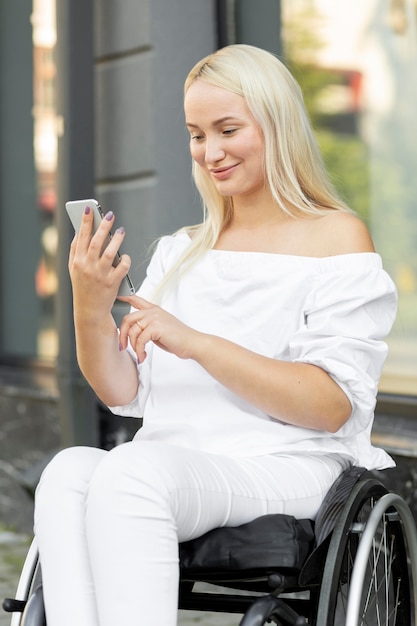 Vrouw in rolstoel met smartphone