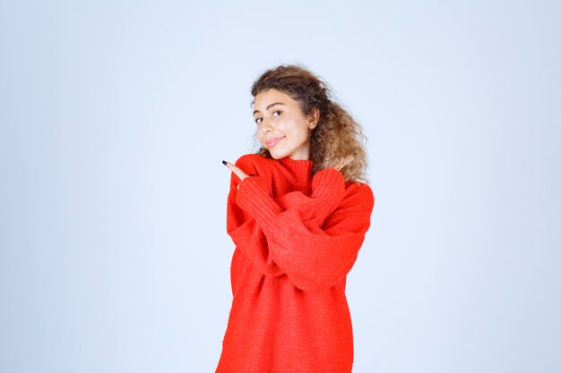 vrouw in rood overhemd wijzend op iets aan de linkerkant.