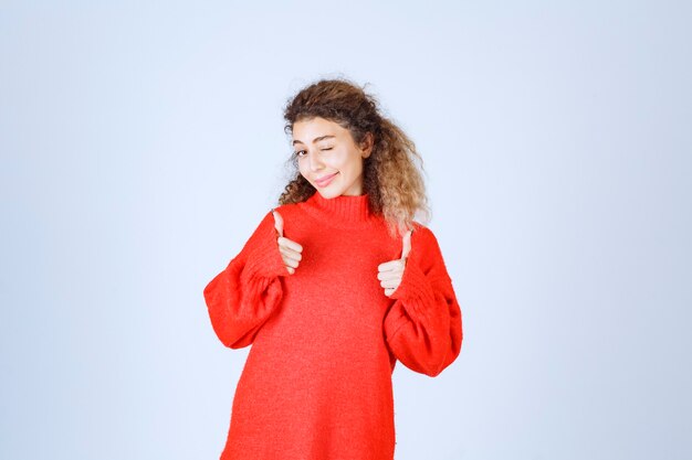 vrouw in rood sweatshirt dat plezierteken toont.