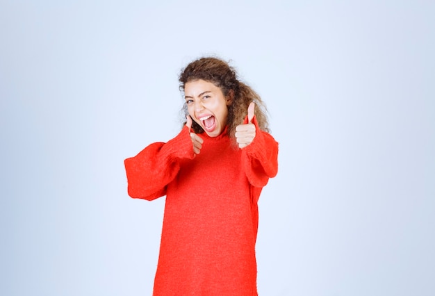 vrouw in rood sweatshirt dat plezierteken toont.