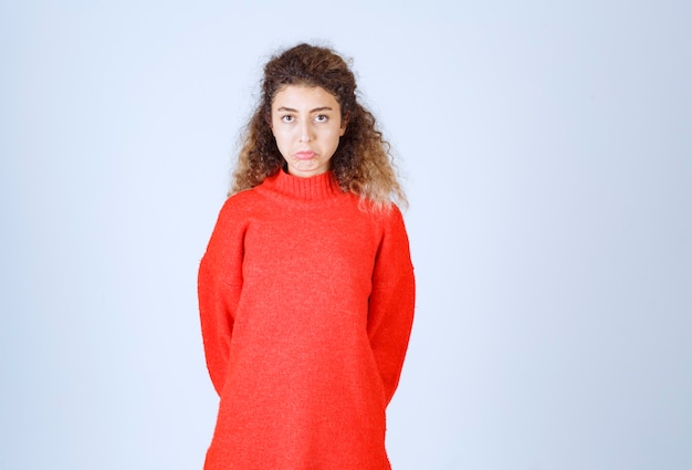 Vrouw in rood sweatshirt die neutrale poses geeft.