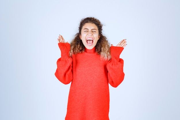 vrouw in rood sweatshirt die vrolijke en positieve poses geeft.