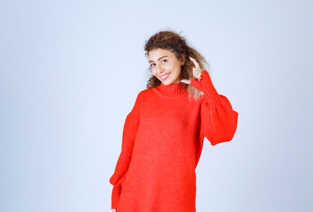 vrouw in rood sweatshirt met de geschatte hoeveelheid of grootte van een product.