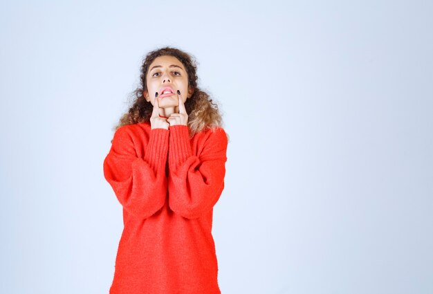 vrouw in rood sweatshirt wat haar glimlach betekent.