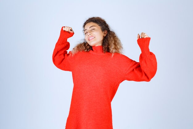 vrouw in rood sweatshirt ziet er moe en slaperig uit.