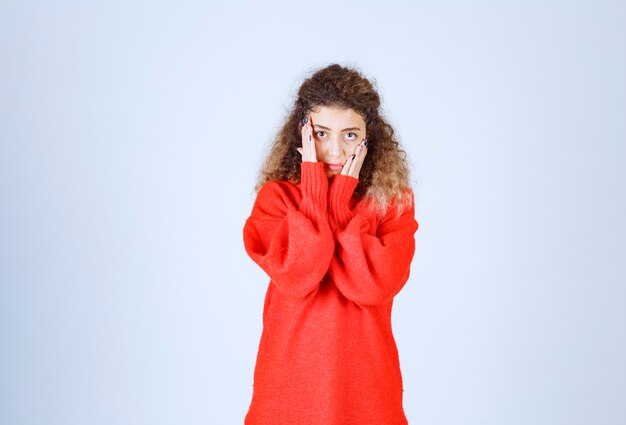 vrouw in rood sweatshirt ziet er uitgeput en slaperig uit.