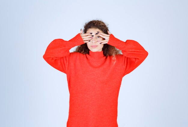 vrouw in rood sweatshirt ziet er uitgeput en slaperig uit.