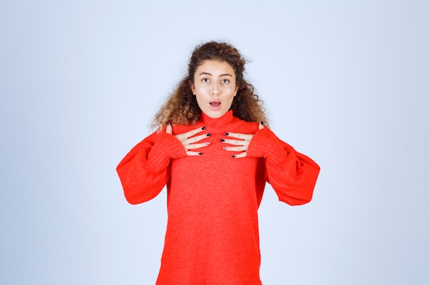 vrouw in rood sweatshirt ziet er verward en attent uit.