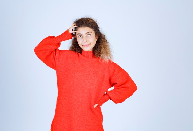 vrouw in rood sweatshirt ziet er verward en verloren uit.