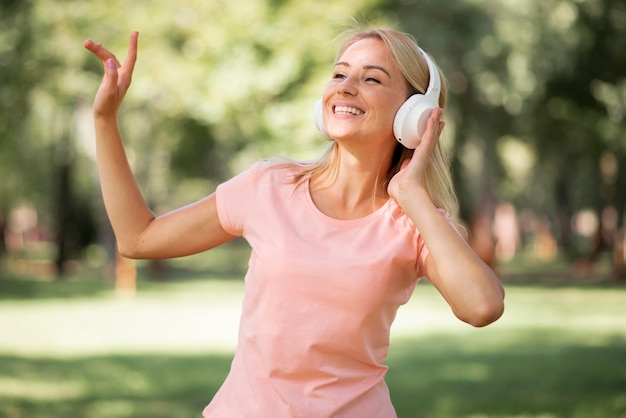 Vrouw in roze t-shirt luisteren naar muziek