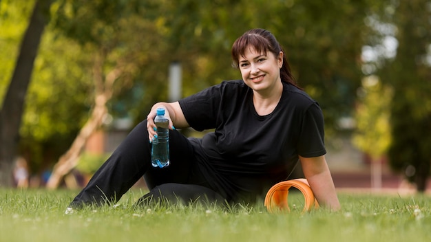 Vrouw in sportkleding met een fles water