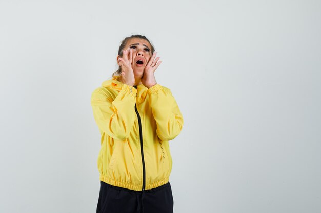 Vrouw in sportkostuum die iets schreeuwt of aankondigt en angstig kijkt, vooraanzicht.