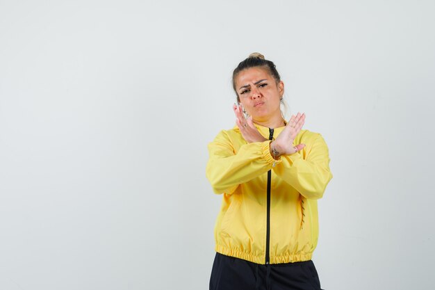 Vrouw in sportkostuum die weigeringsgebaar tonen en geïrriteerd, vooraanzicht kijken.