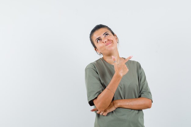 vrouw in t-shirt die opzij wijst en aarzelend kijkt