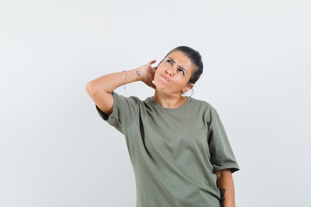 vrouw in t-shirt hoofd krabben en besluiteloos op zoek