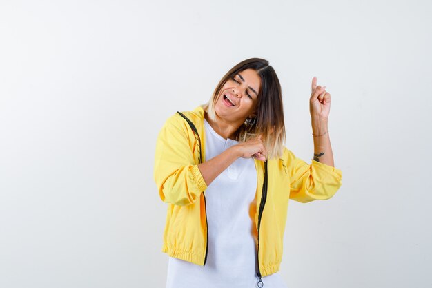 Vrouw in t-shirt, jasje naar boven en energiek, vooraanzicht.