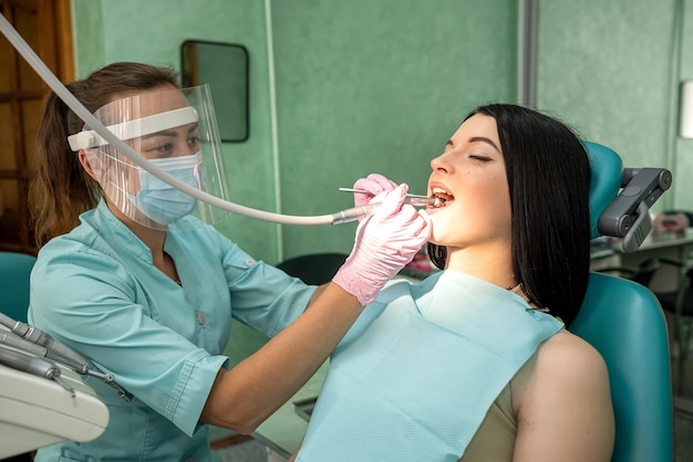 Vrouw in tandartsstoel die haar tand behandelt zonder pijn