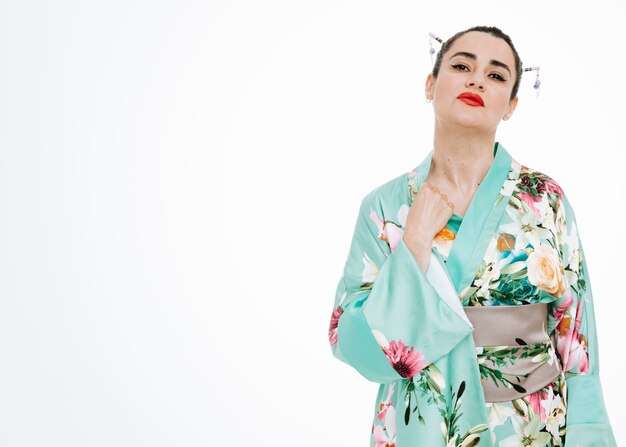 Vrouw in traditionele Japanse kimono die geïrriteerd en geïrriteerd op wit kijkt