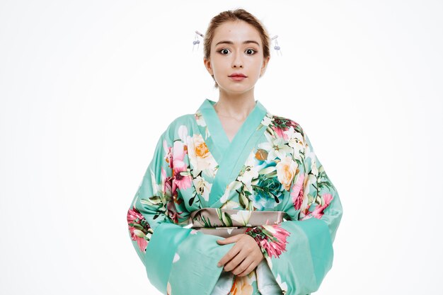 Vrouw in traditionele Japanse kimono gelukkig en positief glimlachend zelfverzekerd op wit