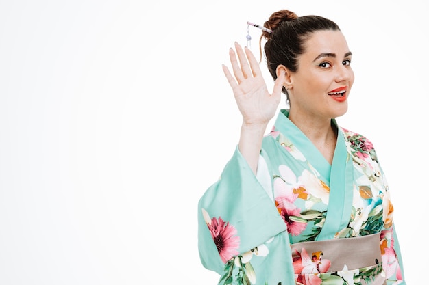 Vrouw in traditionele Japanse kimono gelukkig en positief zwaaiend met de hand lachend op wit