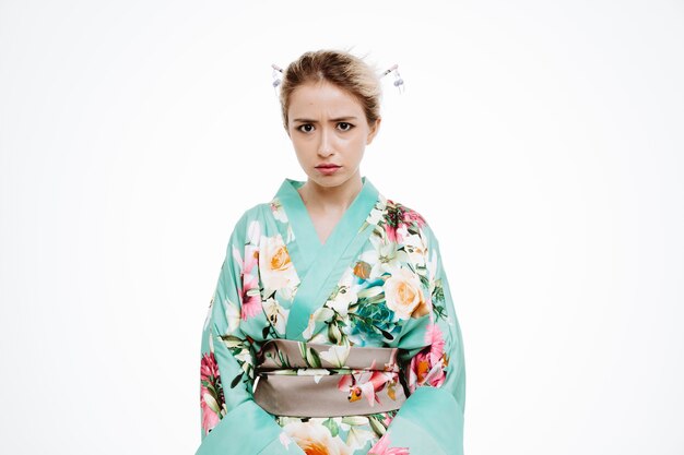 Vrouw in traditionele Japanse kimono met boos fronsend gezicht op wit