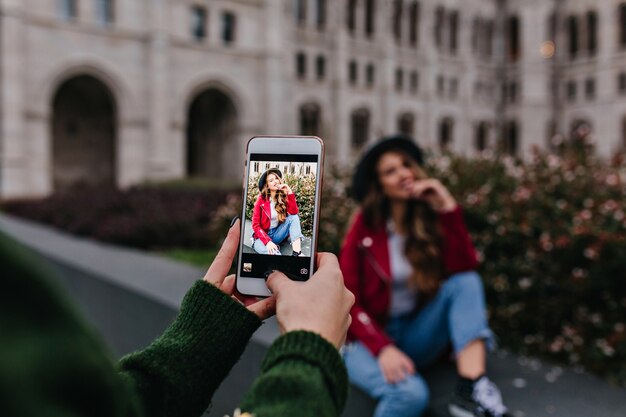 Vrouw in trendy groene trui nemen foto van haar zus naast zitten