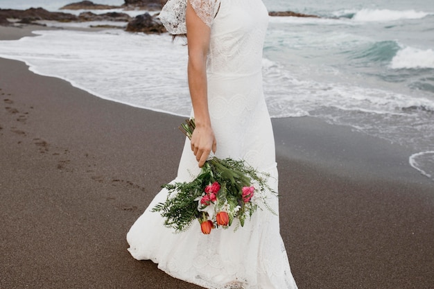 Vrouw in trouwjurk op het strand