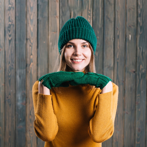 Gratis foto vrouw in trui met de handen onder de kin