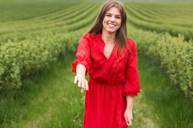 Vrouw in veld met uitgestrekte hand