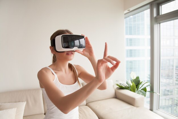 Vrouw in VR-hoofdtelefoon aanraken van virtuele objecten